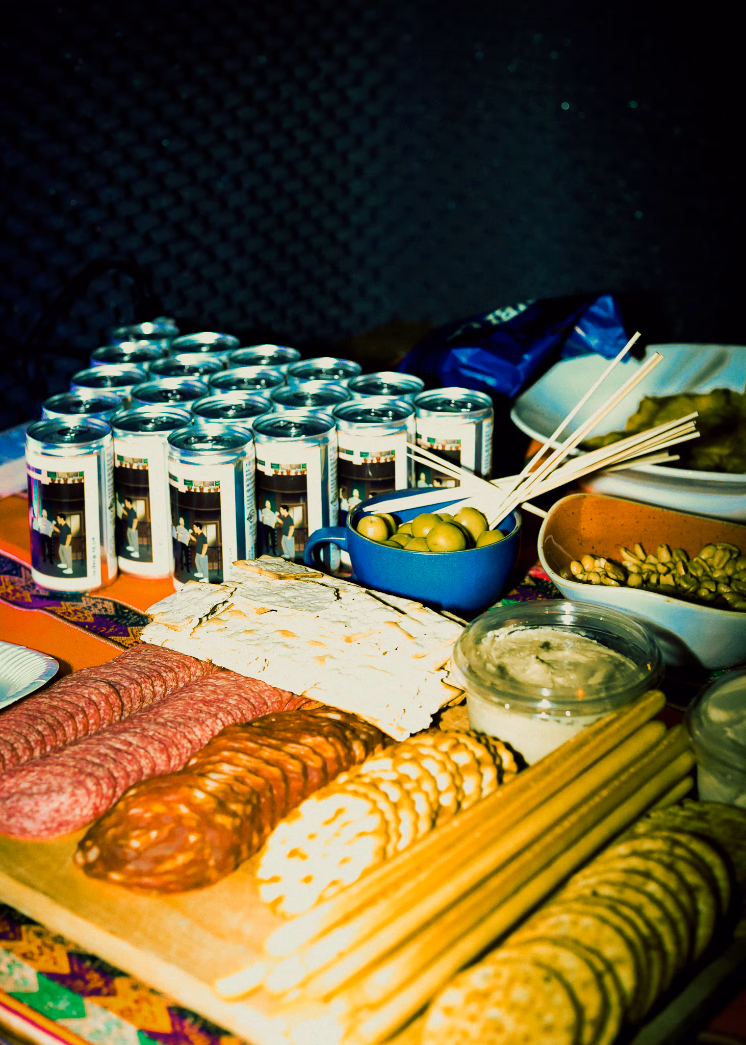 SIP cans with charcuterie, olives and flatbreads